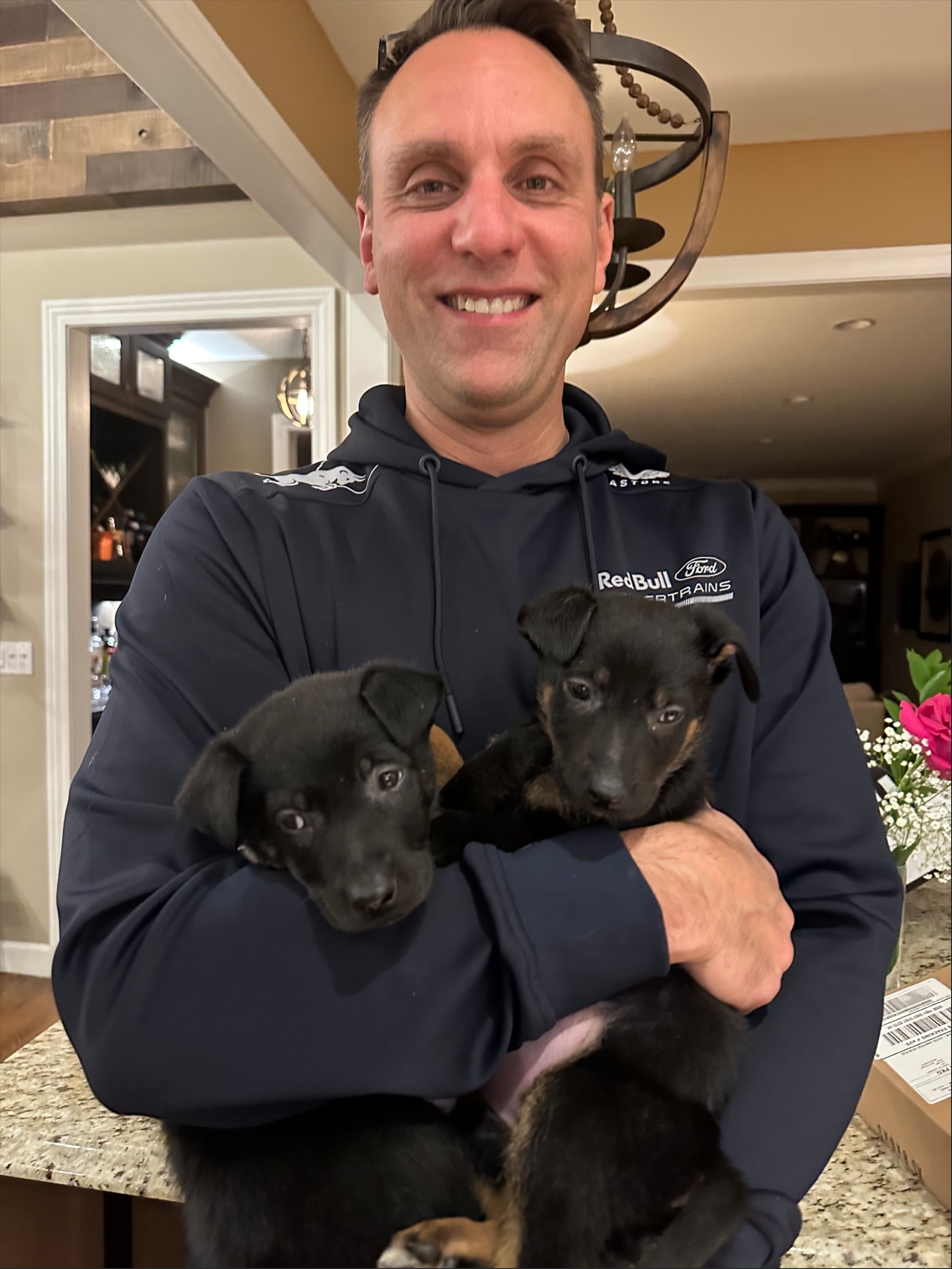 Jim holds two foster puppies, Dallas and Phoenix.